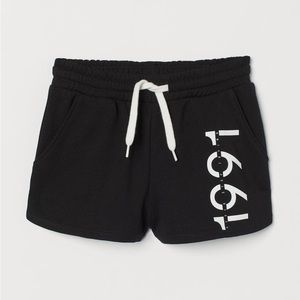 Sweatshorts w/ printed design on one leg. drawstring waistband and side pockets.